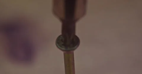 A CloseUp Image of a Screwdriver Gradually Approaching the Head of a Metal Screw Stock Footage 297952456