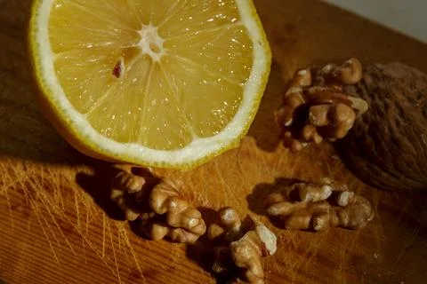 A closeup image showcasing a vibrant, fresh lemon alongside a handful of waln Stock Photos