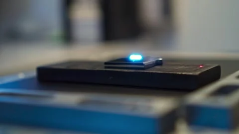 Closeup image showing an advanced technology device emitting a glowing blue Stock Footage 276289095