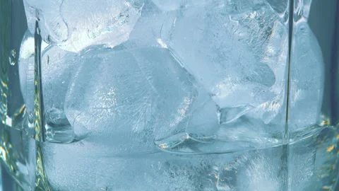 A CloseUp Image of Sparkling Ice Cubes Inside a Clear Glass with Refreshing Beve Vidéo 303658531