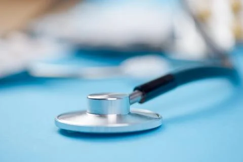 This is a closeup image of a stethoscope placed on a smooth blue surface ba.. Stock Photos