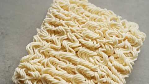 Closeup image of uncooked instant noodles on a grey surface with detailed t.. Stock Footage 291002951