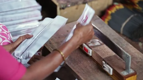 A closeup of incense stick packets being sealed by burning their edges manual Stock Footage 241653204