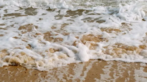 Closeup of incoming waves on sandy beach with sun filmed in slow motion Stock Footage 151293666