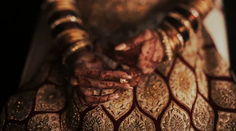 Closeup of Indian bride's hands covered with mehndi and holding a golden Stock Footage 68982519