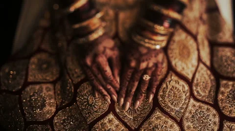 Closeup of Indian bride's hands covered with mehndi and holding a golden Stock Footage 68982538