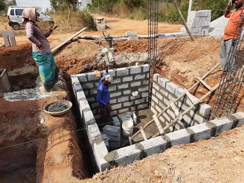 Closeup of Indian workers construction of new building, water sump and mixing Fotos de archivo