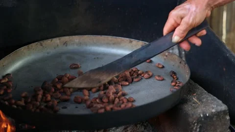 CloseUp of Indigenous Man Roasting Cacao Beans Over Fire with Machete for A.. Stock Footage 278326811