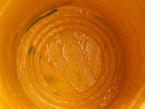 Closeup inside of empty bucket of yellow paint. Stock Photos