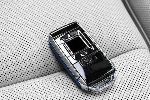 Closeup inside vehicle of wireless blue leather key ignition on white leath.. Stock-Fotos