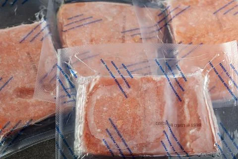 Closeup isolated image of four packs of individually packaged salmon fillets. Stock Photos