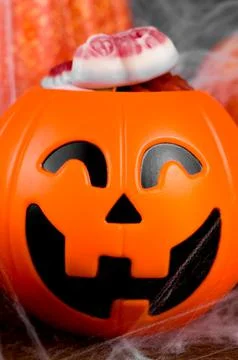 Closeup of jack-o-lanter candy bowl shaped full of sweets decorated with spid Stock Photos