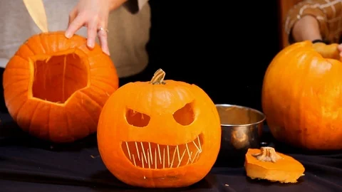 Closeup Jack-O-Lantern People Carving In Background Video stock 98623126