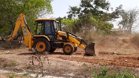 Closeup of JCB cleaning land for construction of building at forest or countr Stock Footage 150863596