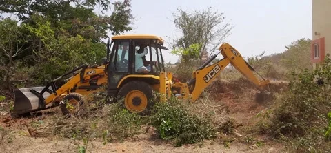 Closeup of JCB cleaning land for construction of building at forest or countr Stock Footage 150863624