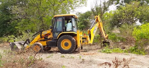 Closeup of JCB cleaning land for construction of building at forest or countr Stock Footage 150863701