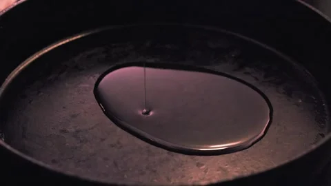 Closeup kitchen view: Oil poured into cast iron pan in dim lighting Video stock 253410473