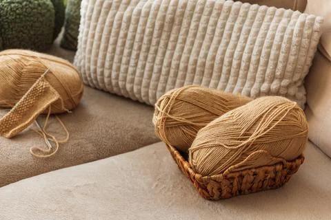 Closeup Knitting Setup with Yarn Basket and Cozy Sofa in Sunlit Living Room. Stock Photos