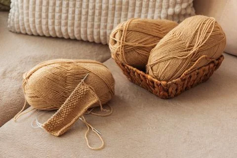 Closeup Knitting Setup with Yarn Basket and Cozy Sofa in Sunlit Living Room. Foto stock