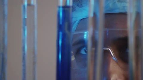 Closeup of a laboratory assistant in goggles observing the diffusion of dissimil Stock Footage 233031158