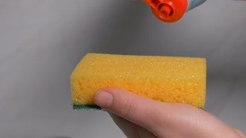 Closeup of a lady cleaning the plates using a viscous detergent. Stock Footage 103306247