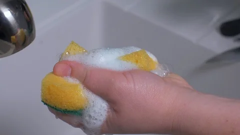 Closeup of a lady cleaning the plates using a viscous detergent. Stock Footage 103310064