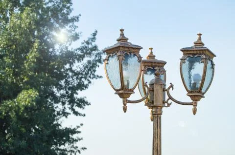 Closeup of a lantern in the Park on the sky background and sun glare Stock Photos