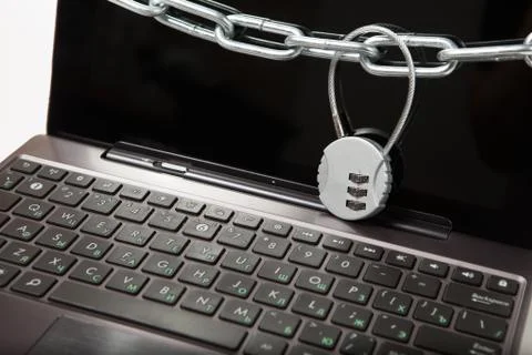 Closeup of laptop with chains and lock. Information security concept. Stock Photos