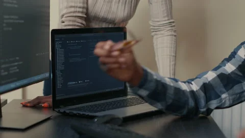 Closeup of laptop running algorithm parsing code on desk in front of programmers Stock Footage 168234298