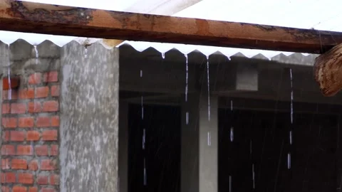 Closeup of large drops of intense rain falling from the calamine roof on the Stock Footage 164620599