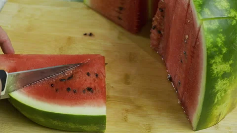Closeup large knife cutting watermelon slices into triangles Stock Footage 341210282