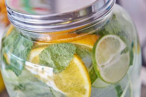 Closeup of A Large Lemonade Jar with Mint Leaves and Limes Foto stock
