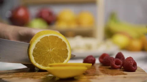 Closeup up of large, sharp knife cutting through juicy orange in kitchen Stock Footage 341231755