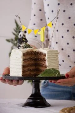 Closeup of large white cake in the hands of girls. Festive delicacy for birth Stock Photos