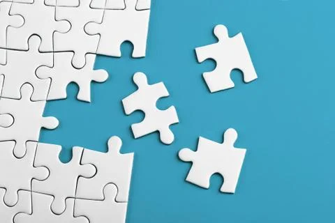 Closeup of the last piece of puzzle missing on blue background Stock Photos