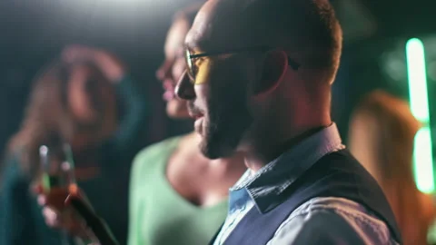 Closeup laughing trendy man dancing at night party event drinking beer relaxing Stock Footage 165035597