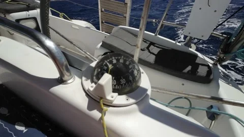 Closeup on left  sailing boat compass and helm looking through steering Stock Footage 238942744