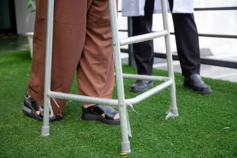 Closeup legs of elderly patient while doctor guidance therapy with walker i.. Stock-Fotos