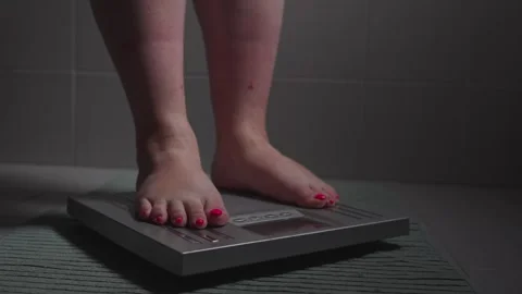 Closeup of legs getting on the scale Stock Footage 289735031