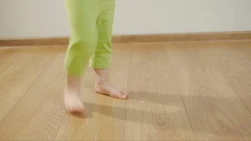 Closeup of the legs of a young child dancing and stomping on a wooden floor in a 스톡 동영상 85614968