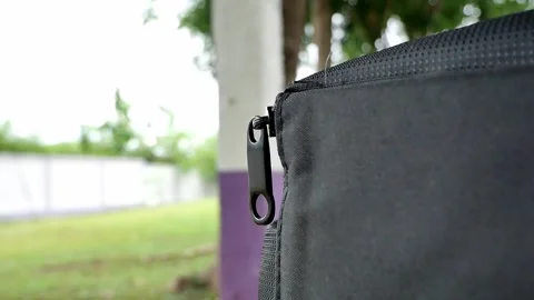 Closeup, A light breeze causes the zipper on the black bag. Stock Footage 259484265