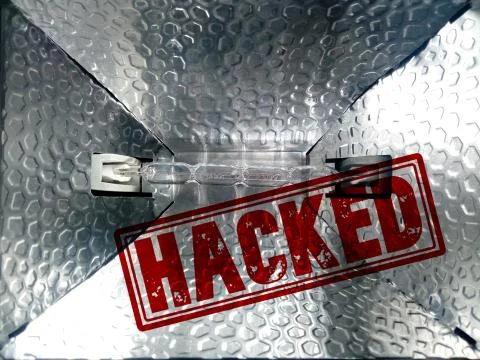 A closeup of a light projector with a red "Hacked" stamp - privacy protection 写真素材