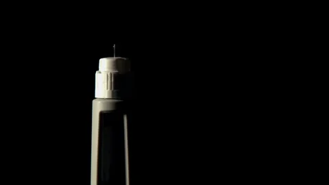 Closeup: Light sweeps across isolated injection needle with droplet Stock Footage 333475357