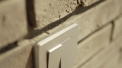 Closeup of light switch and person pressing button with finger to turn on light. Stock Footage 296018657