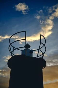 Closeup of lighthouse and clouds at sunset in a coastal area. Stock Photos
