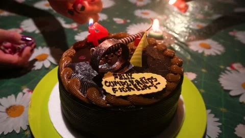 Closeup lighting a chocolate cake candles to celebrate and sing a birthday Stock Footage 146145302