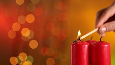Closeup of lighting three christmas candles - on blurry xmas lights background Video stock 81265989
