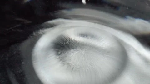 Closeup of Liquid Droplet Creating Ripple Pattern on Reflective Surface in Stock Footage 340801907