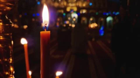 Closeup of a lit candle on the candlestick inside a Christian Orthodox chur.. Stock Photos