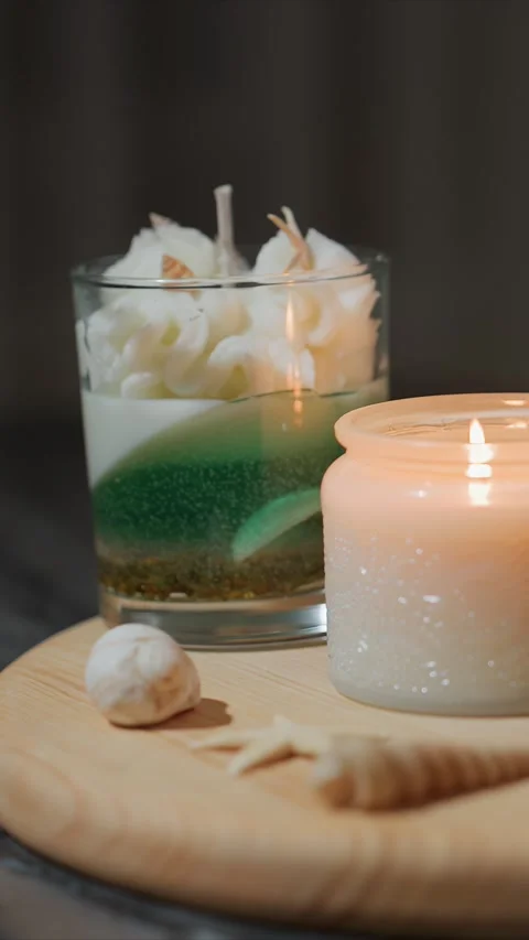 Closeup of lit decorative layered wax candle and seashell themed objects on Vídeo Stock 344675021